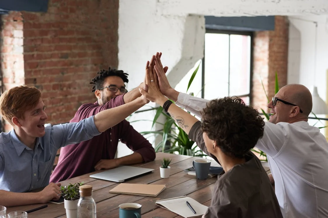 Four people are doing high five